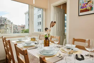 a dining room table with glasses and plates and a window at Stunning 3BR 3Bathroom 3AC near Metro D3 in Istanbul