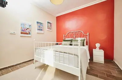 a bedroom with a white bed against a red wall at Stunning 3BR 3Bathroom 3AC near Metro D4 in Istanbul