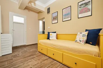 a bedroom with a yellow bed with pillows on it at Stunning 3BR 3Bathroom 3AC near Metro D5 in Istanbul