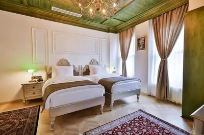 a bedroom with two beds and a chandelier at Emerald Mansion Hotel in Istanbul