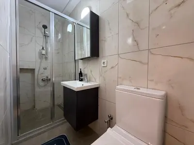 a bathroom with a shower and a toilet and a sink at Stunning 3BR 3Bathroom 3AC near Metro D6 in Istanbul