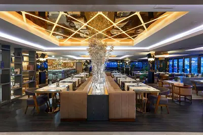 a dining room with tables and chairs and a large long table at Nidya Hotel Esenyurt in Istanbul