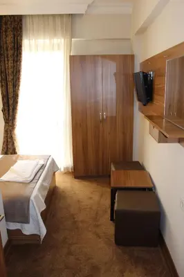 a room with a bed and a table and a tv at Grand Laleli Hotel in Istanbul