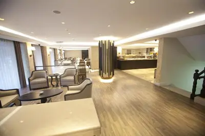 a living room with chairs and tables and a kitchen at Grand Laleli Hotel in Istanbul