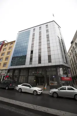 two cars parked in front of a tall building at Grand Laleli Hotel in Istanbul