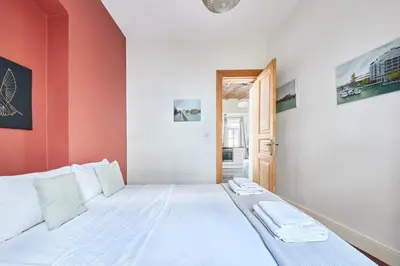 a bedroom with a white bed with red walls at Beautiful restored historical apartment in Galata in Istanbul
