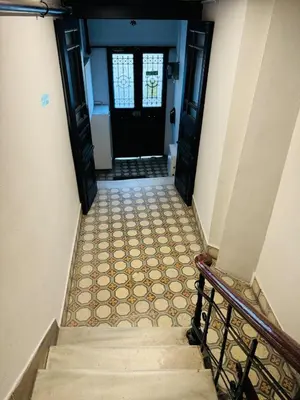 a hallway with stairs leading to a black door at 3BR,Charming Flat,Golden Horn View in Istanbul