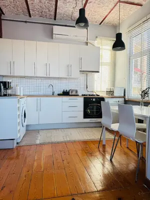 a kitchen with white cabinets and a table and chairs at 3BR,Charming Flat,Golden Horn View in Istanbul