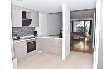 a kitchen with white cabinets and a living room at Yakut Suite in Istanbul
