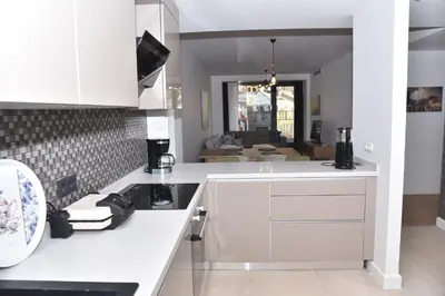 a kitchen with white cabinets and a living room at Yakut Suite in Istanbul