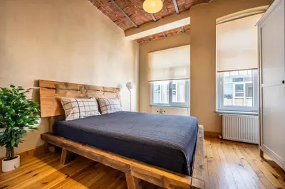 a bedroom with a wooden bed and two windows at Classic Historical Galata Apartment in Istanbul