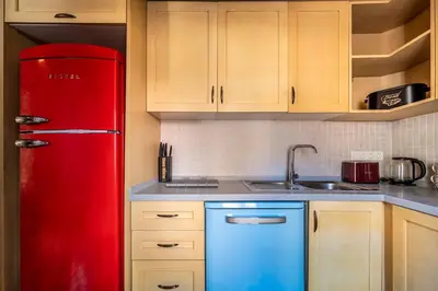 a red refrigerator in a kitchen with a sink at Classic Historical Galata Apartment in Istanbul