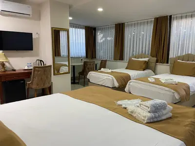 a hotel room with two beds and a desk at Atam Suites in Istanbul