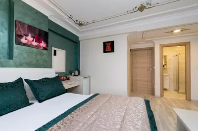 a bedroom with a white bed and green walls at Atam Suites in Istanbul