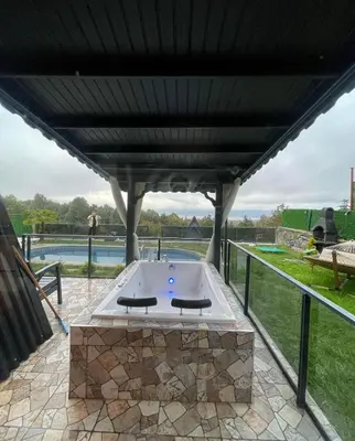a patio with a hot tub under a roof at DREAM DELUXE SAPANCa in Sapanca