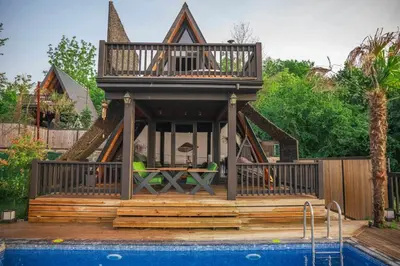 a house with a deck next to a swimming pool at Hill House Bungalov in Sapanca