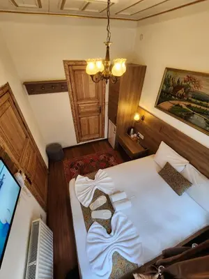 a bedroom with a large white bed and a television at Kadıköy White House in Istanbul