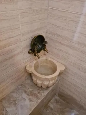 a bathroom with a stone toilet in a tiled wall at Kadıköy White House in Istanbul
