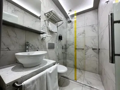 a white bathroom with a sink and a toilet at My Dora Hotel in Istanbul