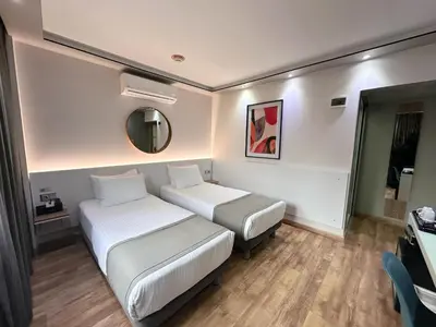 a hotel room with two beds and a mirror at My Dora Hotel in Istanbul