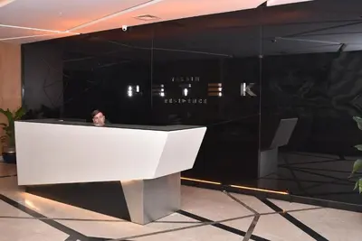 a man standing behind a white podium in a lobby at Safir Suite in Istanbul