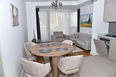 a living room with a wooden table and chairs at Safir Suite in Istanbul