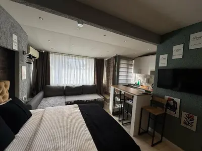 a bedroom with a bed and a couch and a kitchen at The Şişli No Va Park Suites in Istanbul