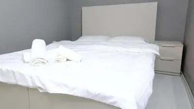 a white bed with white sheets and pillows on it at Rodax Residence in Istanbul
