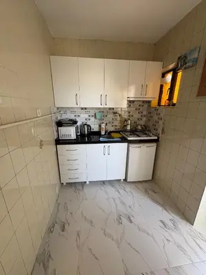 a kitchen with marble floors and white cabinets at Efe Apart Hotel in Istanbul