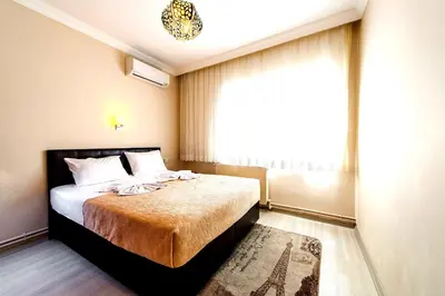 a bedroom with a bed with a window and a rug at Efe Apart Hotel in Istanbul