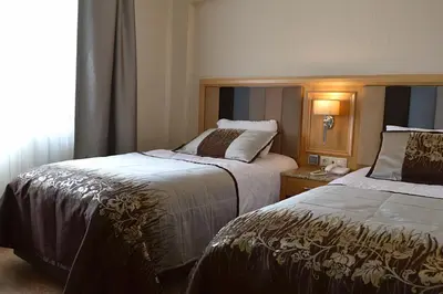 a hotel room with two beds and a window at Hotel Erden Sarayevo in Istanbul