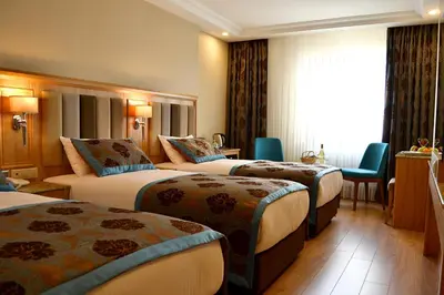 a hotel room with three beds and a window at Hotel Erden Sarayevo in Istanbul