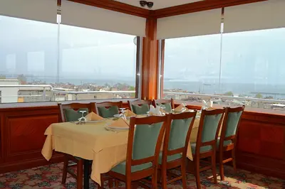 a dining room with a table and chairs and windows at Hotel Erden Sarayevo in Istanbul