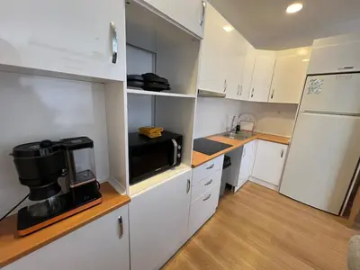 a small kitchen with white cabinets and a microwave at Luxury Designed Comfortable 2 Rooms & 1 Living room Apartment Free Parking Garaj in Esenyurt