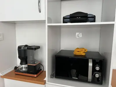 a microwave and a coffee maker on a shelf at Luxury Designed Comfortable 2 Rooms & 1 Living room Apartment Free Parking Garaj in Esenyurt