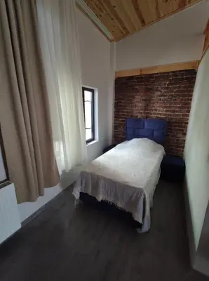 a bedroom with a bed and a brick wall at erdener suits in Istanbul