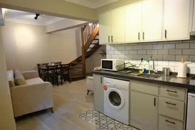 a kitchen with a washer and a living room at A spacious 3 rooms duplex close to İstiklal Boulevard in Istanbul