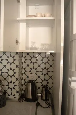 a kitchen with white cabinets and black and white tiles at Luxe Suite AY38 in Eskiömerler