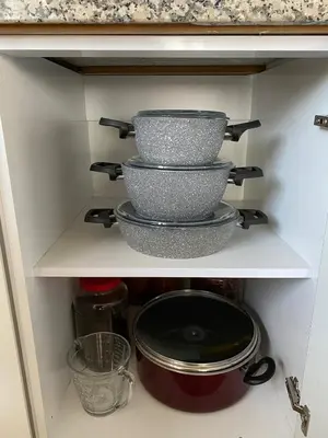 a shelf with three pots and pans in a kitchen at Lilyum garden house&organization in Söylemiş