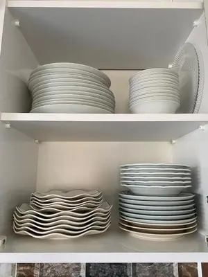 two stacks of plates in a white cabinet at Lilyum garden house&organization in Söylemiş