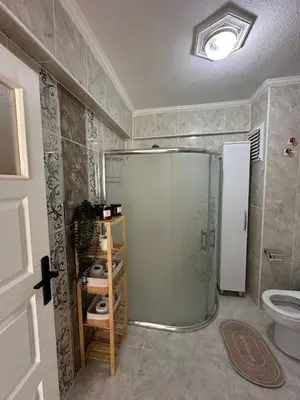 a bathroom with a glass shower and a toilet at Lilyum garden house&organization in Söylemiş