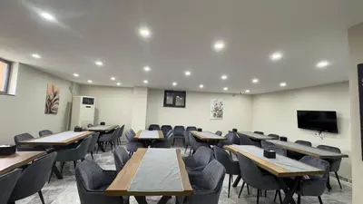a classroom with tables and chairs and a flat screen tv at Lions Boutique Hotel in Altınova