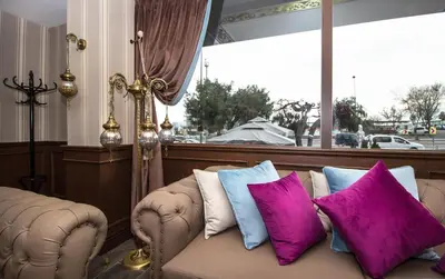 a couch with purple and blue pillows in front of a window at Le Marde Hotel in Istanbul