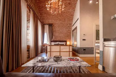 a living room with a chandelier and a brick wall at Stone Inn Galata in Istanbul