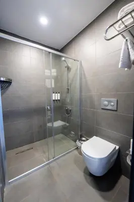 a bathroom with a toilet and a glass shower at Educity Hotels & Spa in Istanbul