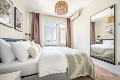 a white bedroom with a bed and a mirror at Stay Beyond the Bosphorus #6 in Istanbul