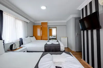 a hotel room with two beds and a flat screen tv at JAMMY Hotel in Istanbul
