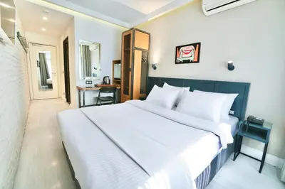 a bedroom with a large white bed and a desk at Fitas Oda Hotel in Istanbul