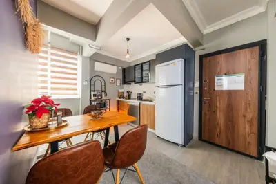 a kitchen with a wooden table and chairs at Cozy Home in Historic Istanbul in Istanbul