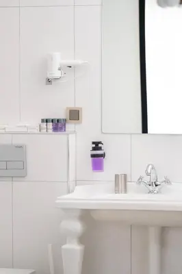 a white bathroom with a sink and a mirror at Cozy Home in Historic Istanbul in Istanbul